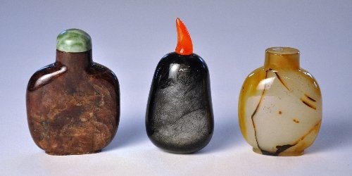 A collection of three snuff bottles including a Chinese: A collection of three snuff bottles including a Chinese matrix ruby chalcedony with brown markings and a hair crystal pebble