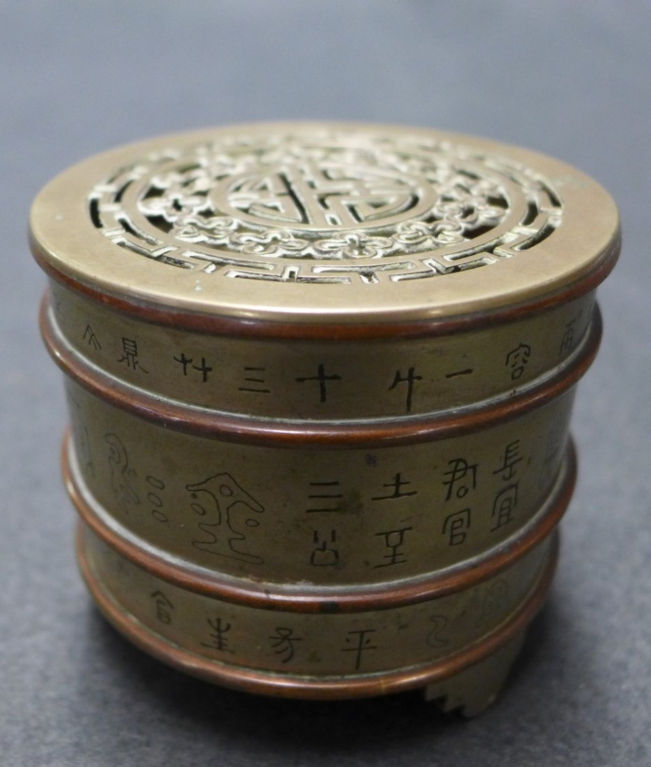 A Late C19th Chinese Pak Tong Brass Incense Clock: A late C19th Chinese Pak Tong brass incense clock on stepped feet. Height 7.3cm, Diam 8.5cm.
