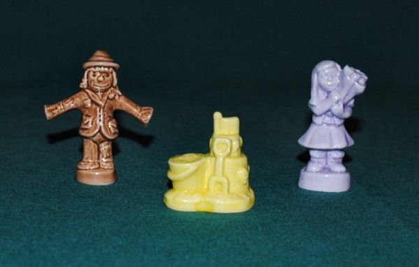 Lot of 3 Wade Figurines: Brown scarecrow, purple girl holding flowers and yellow sandcastle. 1.5-2"h. 2 oz. Excellent; no chips or cracks.