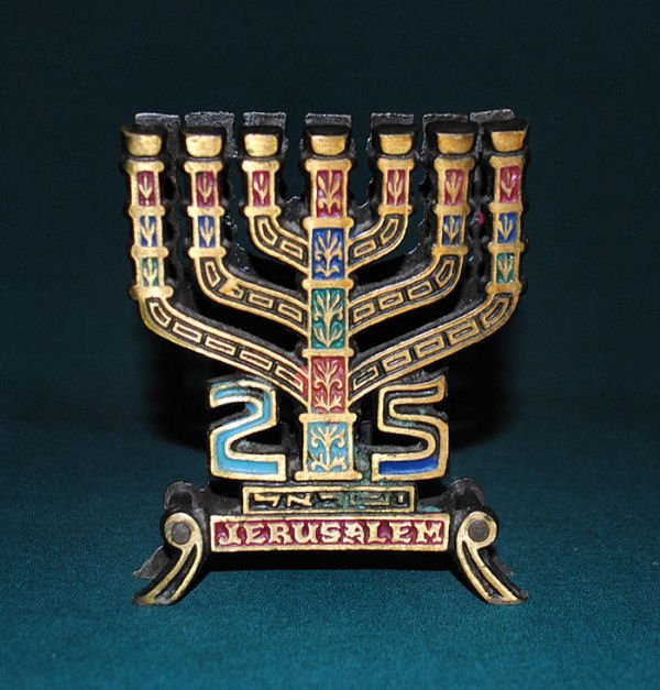 Hand Painted Brass Menorah Card/Letter Holder: Small patinated brass hand painted Menorah with numbers 25 and Jerusalem featured at the bottom. Opening to hold letters or cards. 3.5"w x 4"h.