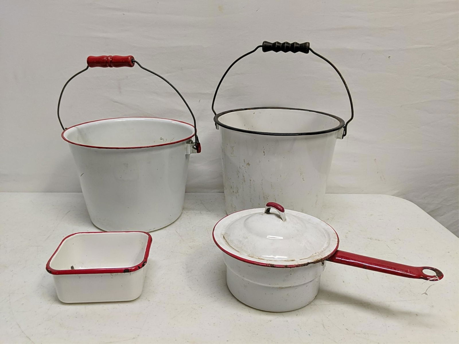 Vintage 4 pieces of enamel ware: 3 pieces of red and white and 1 piece of black and white 2 10" pots 1 6 1/2" sauce pan and 1 54 5/8" x 5" greas pan