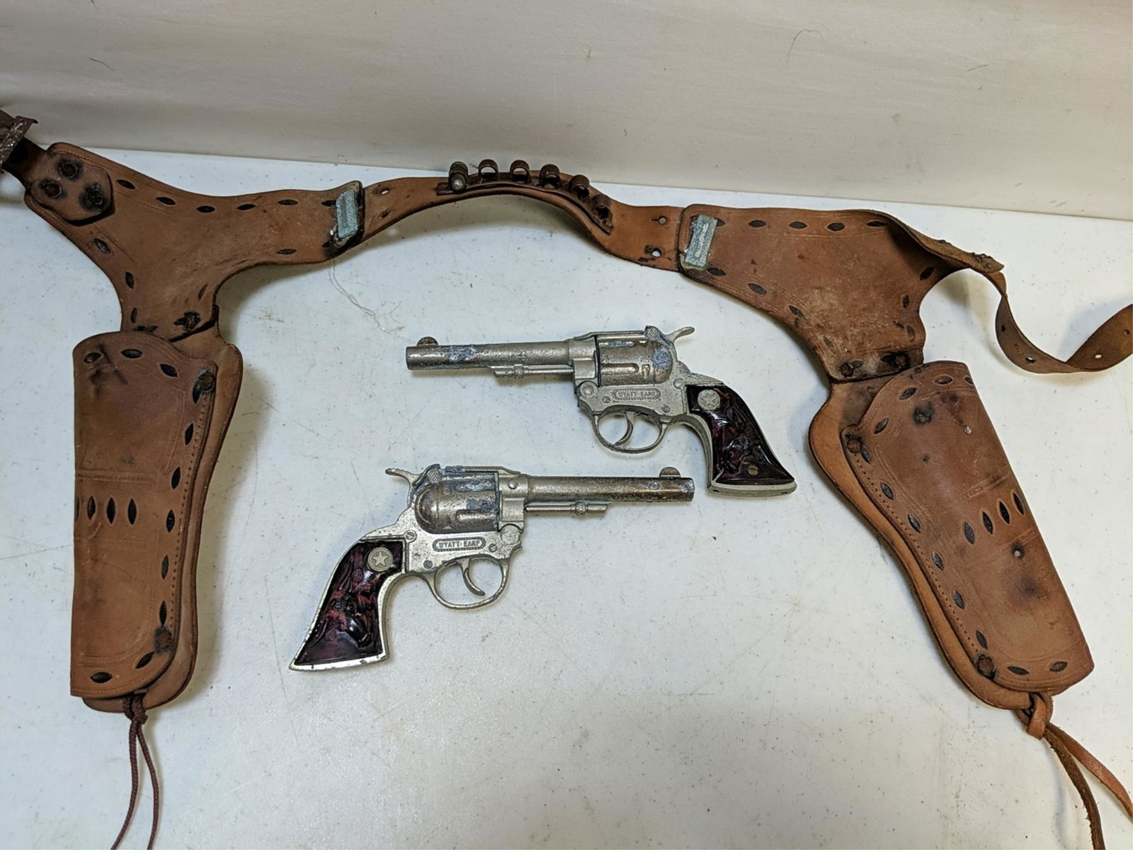 Vintage Wyatt Earp cap guns and holster: some corrosiion on cap guns and metal trim on holster used condition