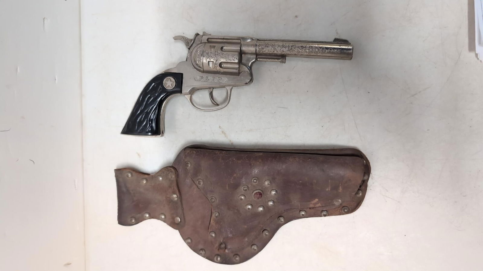 Vintage Flip Cap Gun and leather holster: gun is in working condition 9 1/2" long