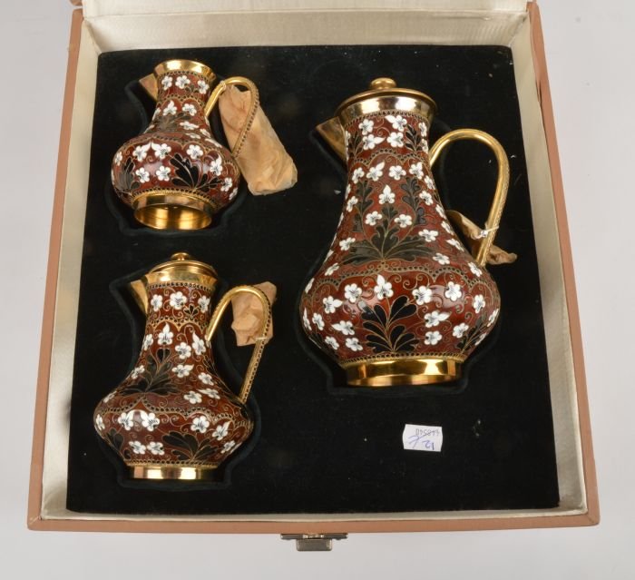 A graduated set of three Soviet Russian silver col: A graduated set of three Soviet Russian silver coloured gilt and enamel baluster jugs and covers, post 1958 .916 standard, circa 1974, with floral decoration on a brown ground, 20.5cm (8in),