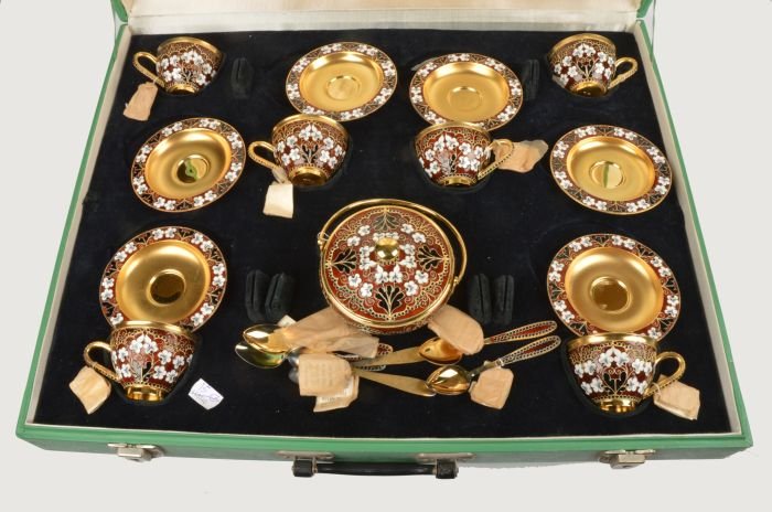 A Soviet Russian silver coloured gilt and enamel c: A Soviet Russian silver coloured gilt and enamel coffee service, post 1958 .916 standard, circa 1974, with floral decoration on a brown ground, comprising six of coffee cups, saucers and spoo