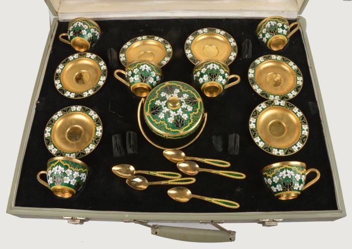 A Soviet Russian silver coloured gilt and enamel c: A Soviet Russian silver coloured gilt and enamel coffee service, post 1958 .916 standard, circa 1971, with floral decoration on a green ground, comprising six of coffee cups, saucers and spoo