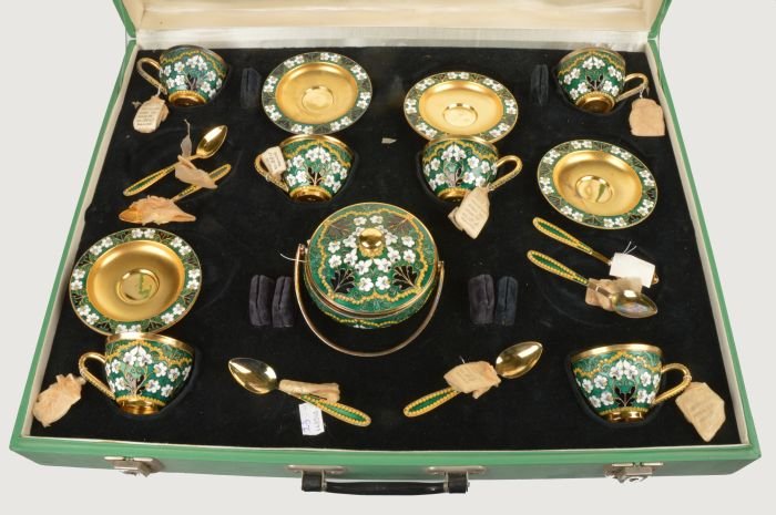 A Soviet Russian silver coloured gilt and enamel c: A Soviet Russian silver coloured gilt and enamel coffee service, post 1958 .916 standard, circa 1974, with floral decoration on a green ground, comprising six of coffee cups, saucers and spoo
