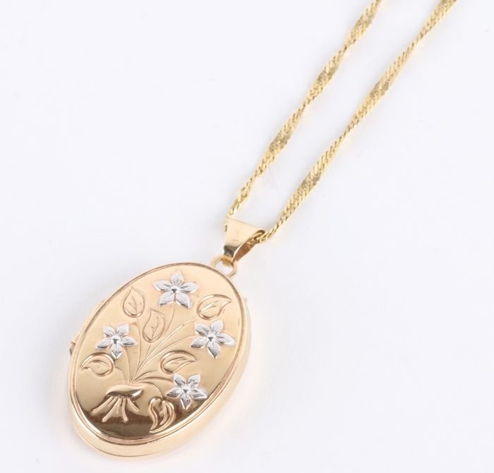 A 9 carat two colour gold locket, of oval shape wi: A 9 carat two colour gold locket, of oval shape with floral decoration, 3cm long including bale, 3.1g gross; a fancy link chain, stamped '14K', 44cm long, 2.3g gross; and a single stone penda