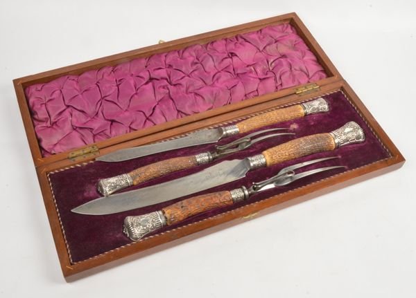 A cased four piece stag horn handled carving set w: A cased four piece stag horn handled carving set with silver ferrules and terminals by Harrison Brothers & Howson, Sheffield 1982, with gadrooned and foliate decoration, the carving knife 40.5cm l