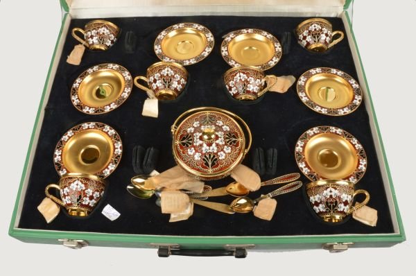 A Soviet Russian silver coloured gilt and enamel c: A Soviet Russian silver coloured gilt and enamel coffee service, post 1958 .916 standard, circa 1974, with floral decoration on a brown ground, comprising six of coffee cups, saucers and spoons a