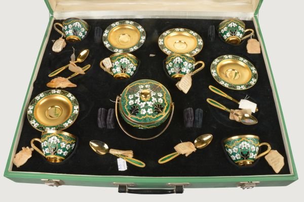 A Soviet Russian silver coloured gilt and enamel c: A Soviet Russian silver coloured gilt and enamel coffee service, post 1958 .916 standard, circa 1974, with floral decoration on a green ground, comprising six of coffee cups, saucers and spoons a