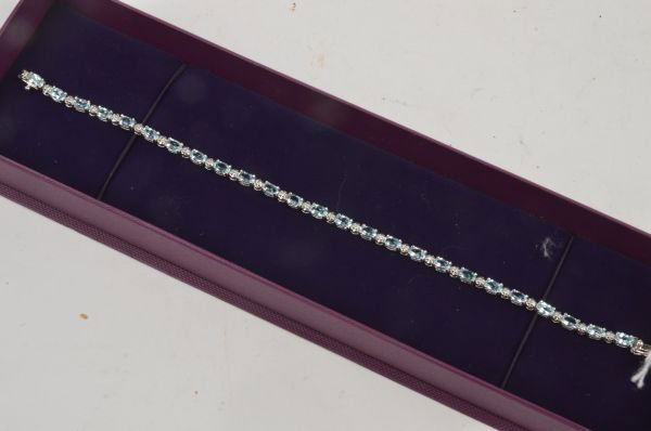 A blue topaz and diamond line bracelet, alternatel: A blue topaz and diamond line bracelet, alternately claw set with oval shape blue topaz with single-cut diamond points between, on a snap clasp, mount hallmarked 9ct gold, 19cm long, weight 8.5g gross