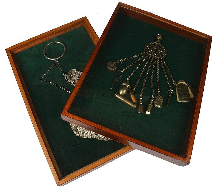 A silver mesh bag by Elkington Co. Ltd., London: A silver mesh bag by Elkington & Co. Ltd., London 1915, suspended on a link chain; and a similar purse, both mounted in a frame; and a framed electro-plated chatelaine, suspending a vesta case, a 