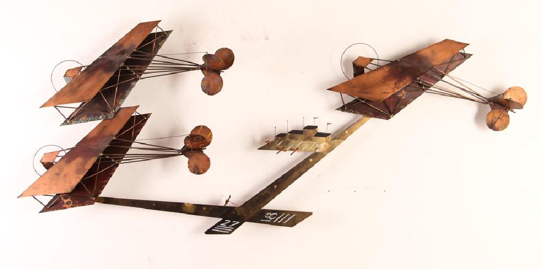 Curtis Jere Airplane Themed Sculpture: Curtis Jere bi-wing airplane and airport sculpture, metal, signed lower right, measuring 24 by 54 by 6 inches.