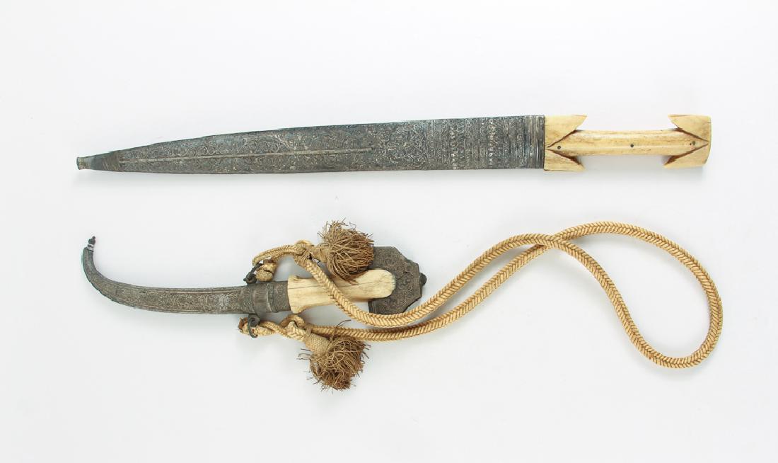 2 Indonesian Kris with Scabbards: Indonesian Kris with Scabbards with extensive repousse floral pattern decoration, bone handles, the longer Kris measures 28.25 inches inside sheaf
