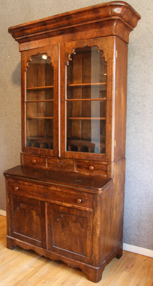 Mahogany Empire Secretary Bookcase: Empire Mahogany secretary bookcase, with a bonnet top and gothic inspired mullioned glass doors, three drawer over a fold out writing surface, over a drawer and two blind doors with matching decoratio