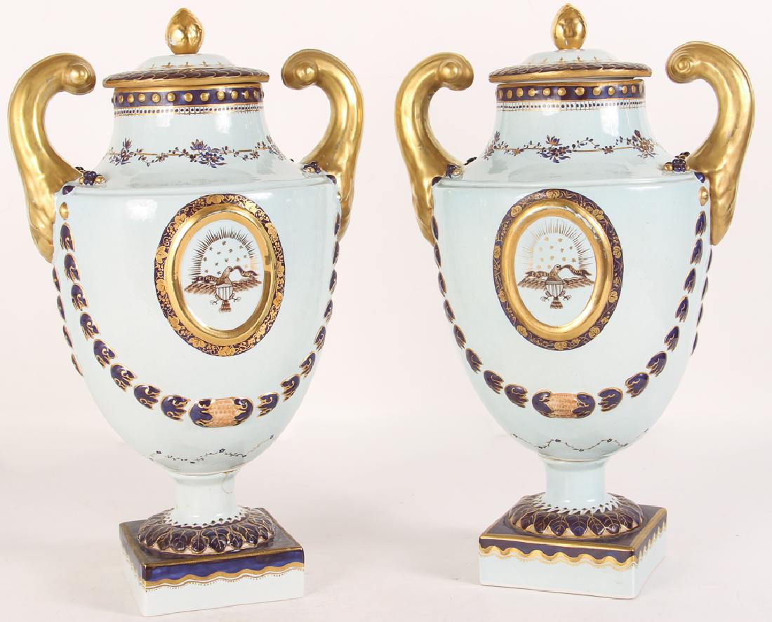 Pair Mottahedeh Lowestoft Federal Eagle Urns: Pair of reproduction Lowestoft Federal Eagle urns, porcelain with painted and gilt decoration, measuring 16.5 by 10 inches.