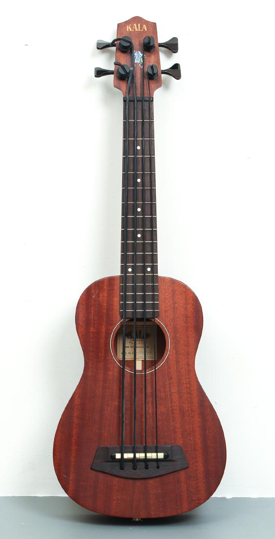 Kala Bass Ukulele and Etc.: Kala bass ukulele, nylon strap, and Crafter Chromatic headstock tuner, all contained in a nylon case. Provenance: Maurice "Mac" Cridlin, who was mainly known as a studio musician active in the San Fra