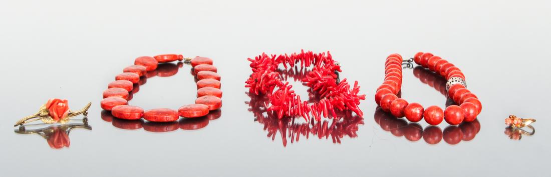 Assorted Coral Jewelry: Three coral necklaces, two with beads, one with natural coral shards, finished with silver fittings. A coral rose pin and coral rose ring. The rose pin is marked 800 silver. The rose ring is set with 