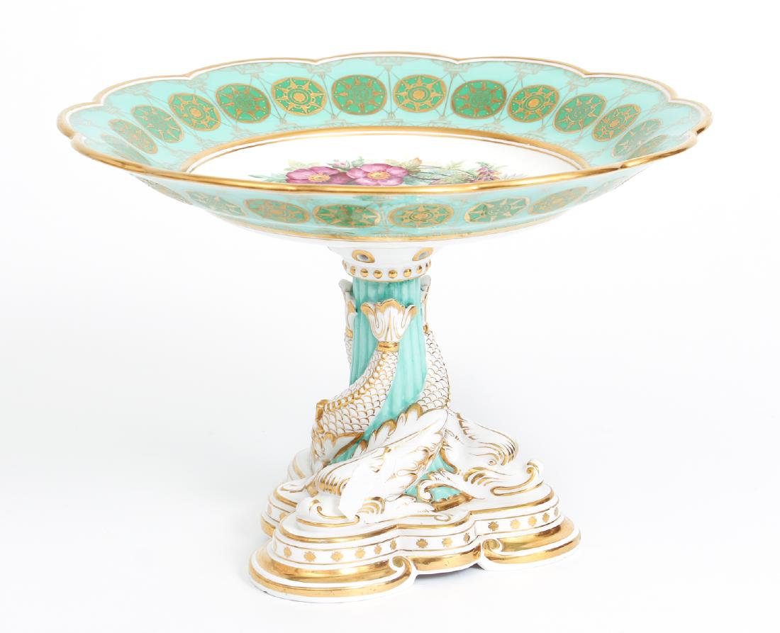 Davenport Porcelain Dolphin Form Centerpiece: Davenport porcelain centerpiece, with a top with hand painted flowers, on a center pedestal decorated with dolphin themes, measuring 8 by 11 inches.