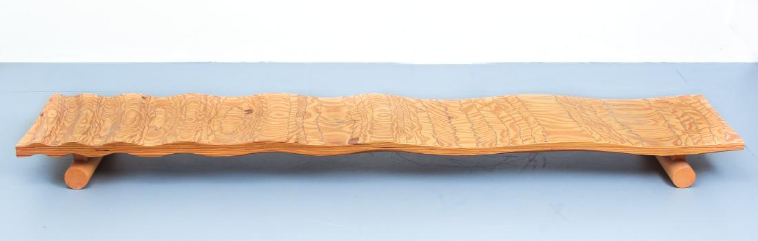Tadao Arimoto Low Wooden Table or Bench: Arimoto, Tadao (Japanese/American, 1949) low carved wooden table or bench, with carved ripple top and cylindrical feet on base, measures 5.25" x 70" x 13.75".