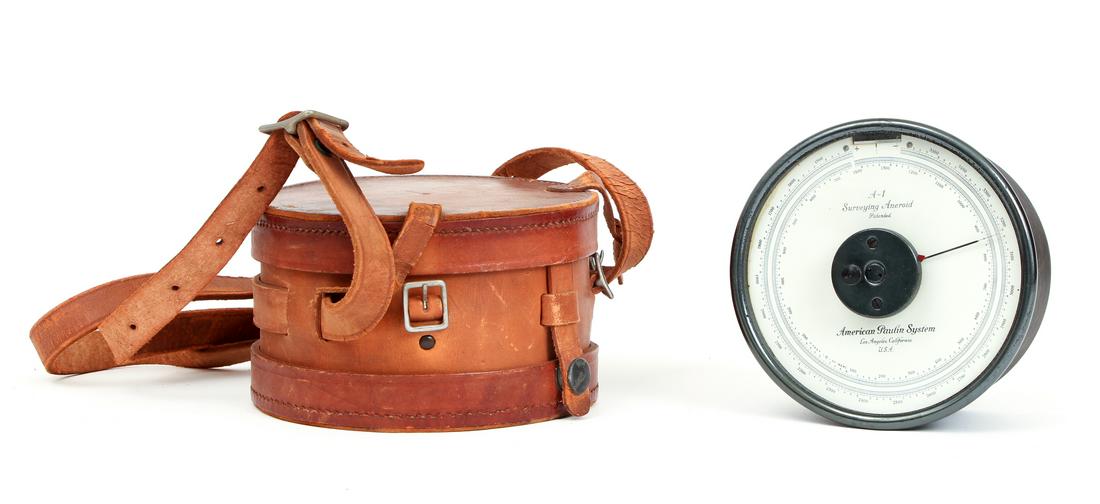 Paulin Surveying Aneroid Altimeter with Carrying Strap: Circular altimeter marked "American Paulin System," includes fitted round light brown leather case with carrying strap, surveying aneroid barometer, 2.75 in. needle, measures 5” in diameter and 2.75