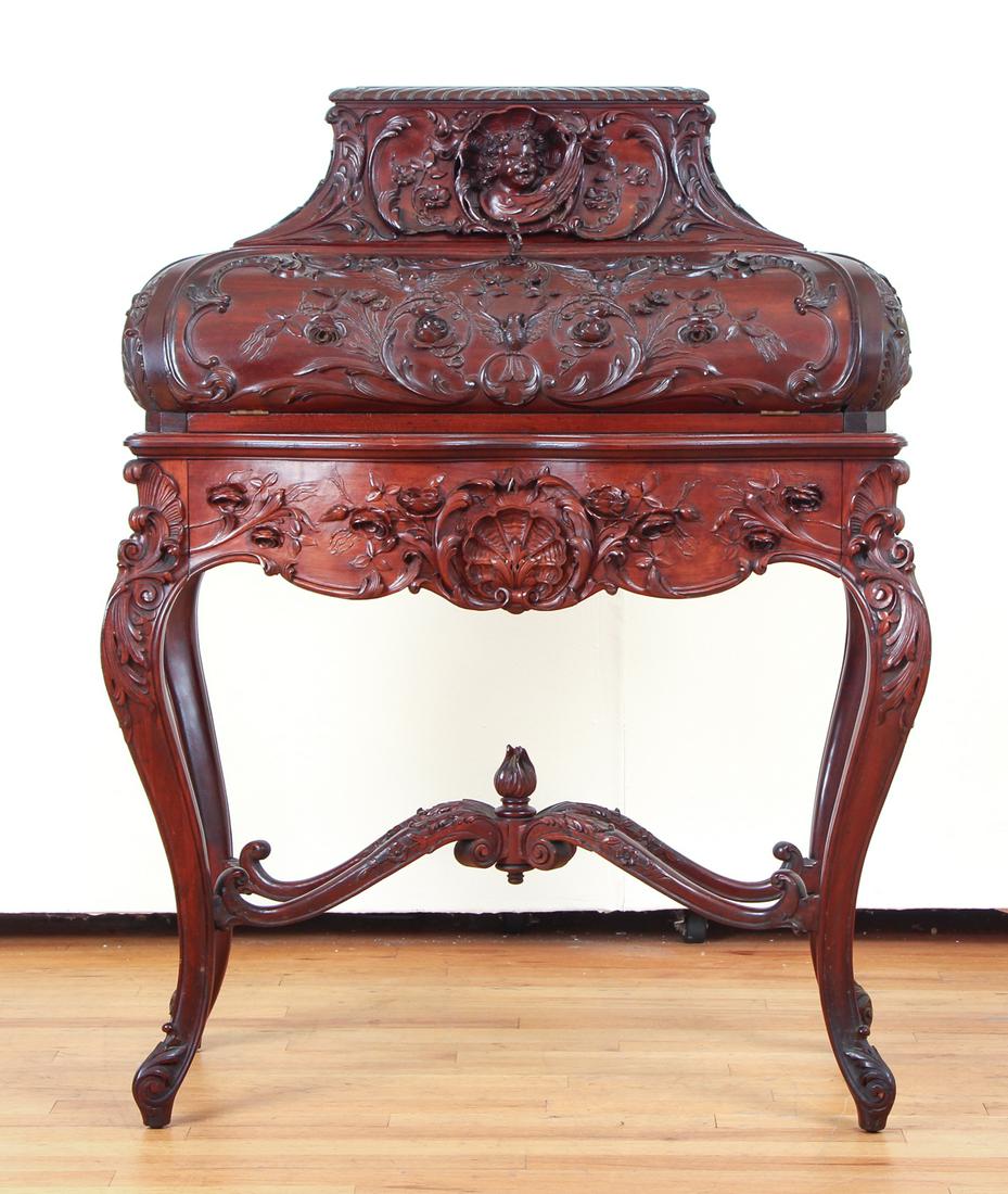 Elaborately Carved Ladies Writing Desk: Ladies writing desk, mahogany with elaborate carving featuring cherubs and birds among rococo decoration, 44 by 32 by 18 inches.