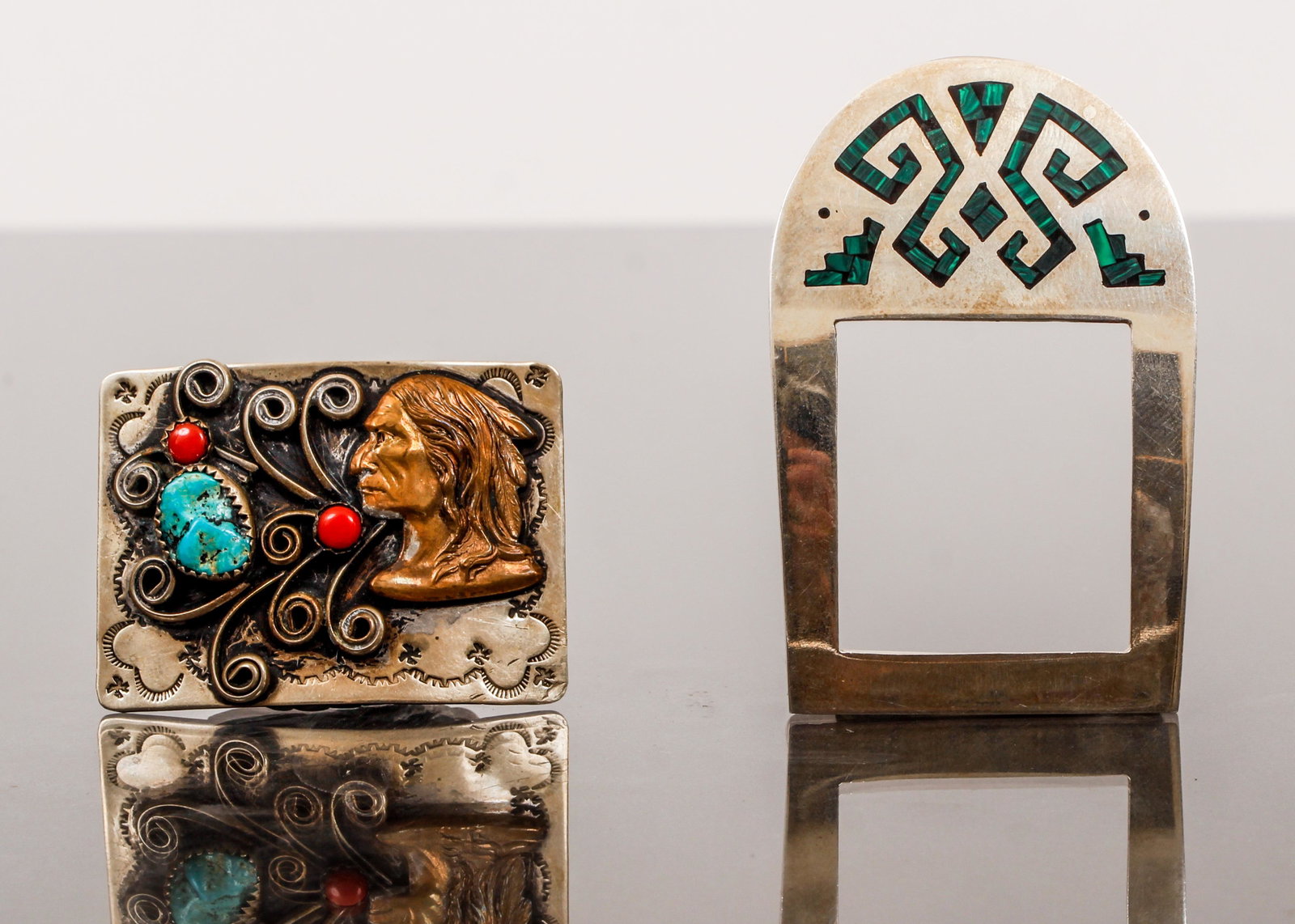 Sterling Squaw Wrap and Taxco Belt Buckles: Sterling squaw wrap and Taxco belt buckles. The Squaw Wrap buckle is decorated with hammered engraving, figural bust, bezel set coral and turquoise stone. Measures 2" x 1 1/2". Marked "Squaw Wrap". Th