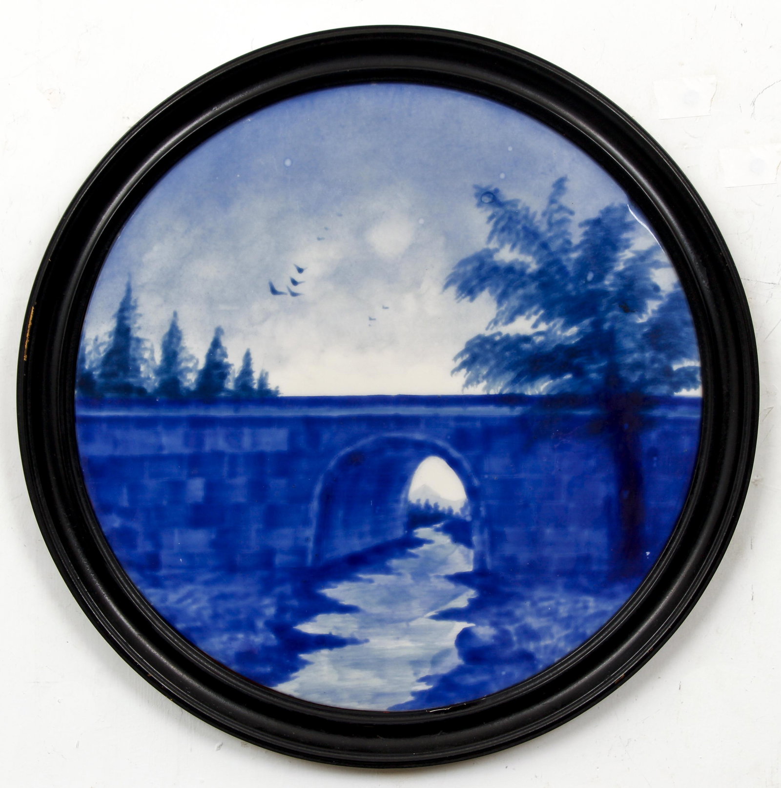Painted Porcelain Roundel Landscape with Bridge: Art Nouveau late 19th or Early 20th Century Round Porcelain Landscape painting with Bridge, 16 inches in diameter, with a round wood frame, 18.5 inches in diameter, The Estate of Bruce Baker.