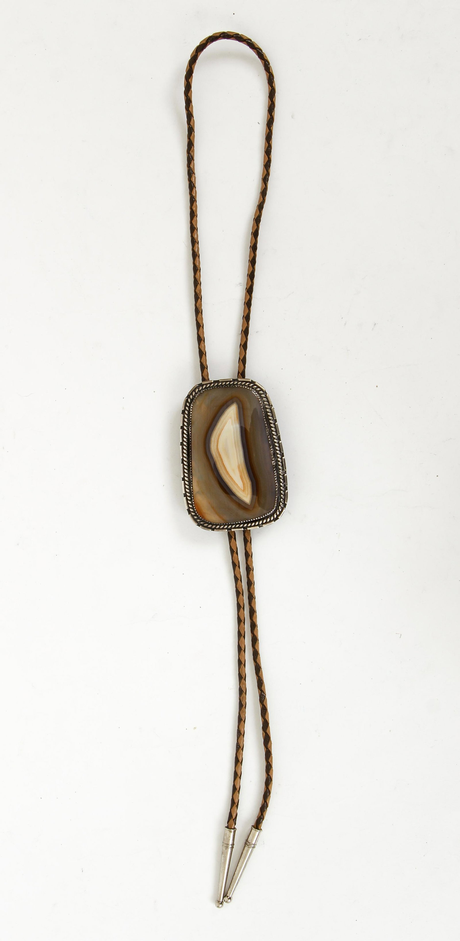 Silver and Agate Bolo Tie: Silver and agate bolo tie. A large slice of polished agate stone is bezel set in this decorative sterling bolo. The mounting measures 3" long, 2" wide with a slight downward taper. The back of the bol