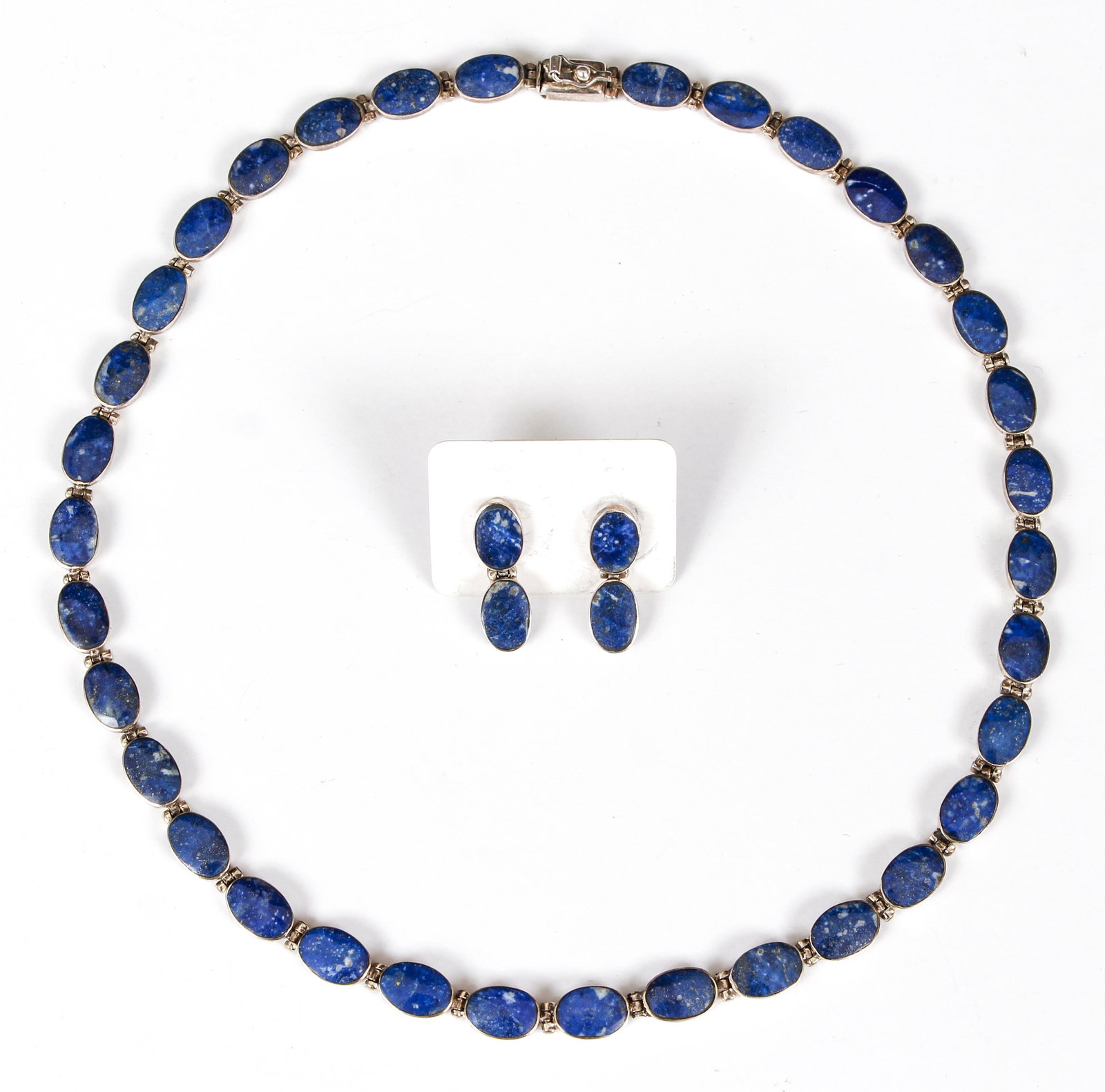 Sterling Lapis Necklace and Earrings: Sterling and lapis necklace and matching earrings. The necklace is crafted of 34 bezel set oval lapis stones connected by pin hinges. Finished with a hidden box closure. Measures 17 1/8" long, 1/4" wi
