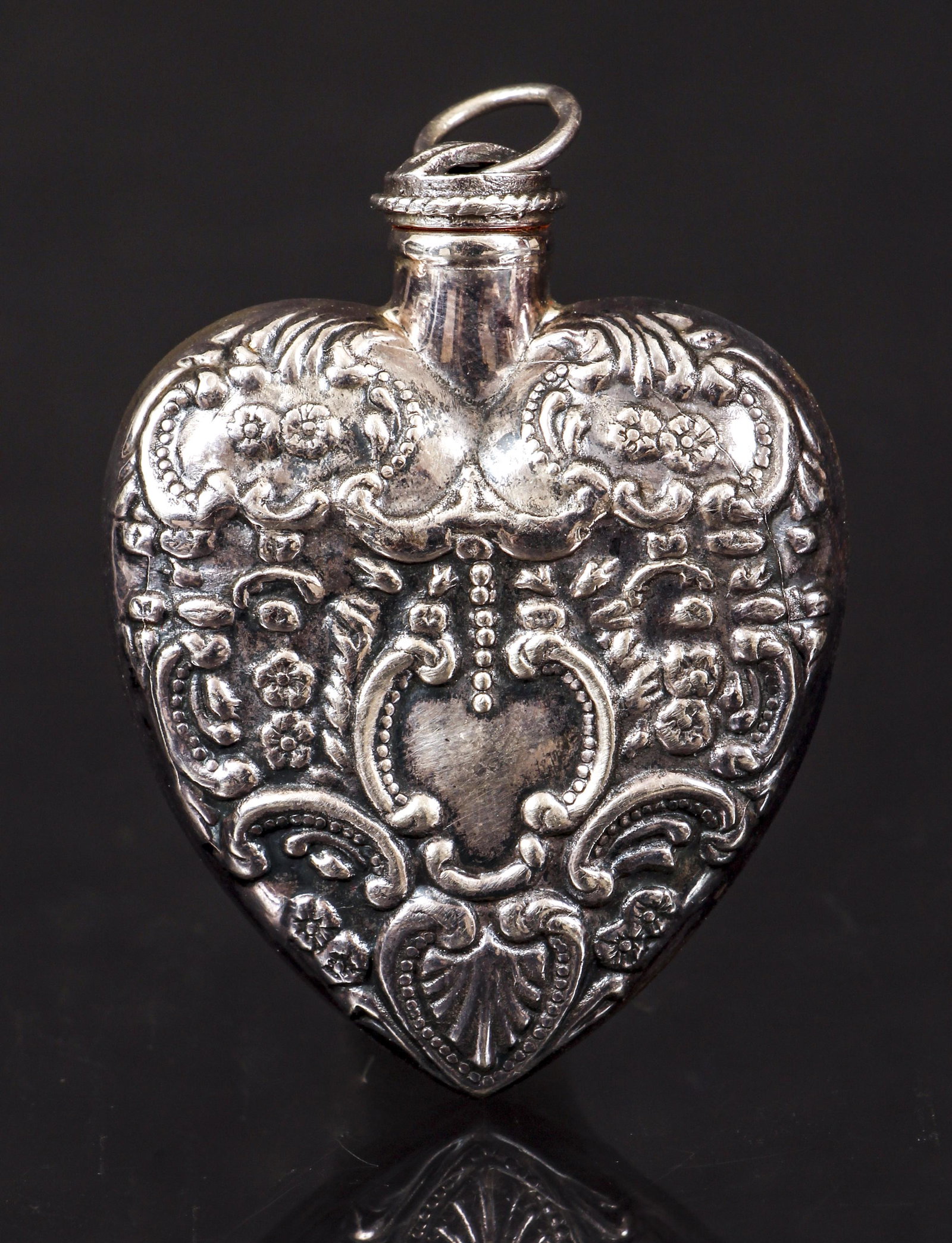 Sterling Antique Style Heart Perfume Pendant: Sterling antique style heart perfume pendant. Fashioned from an antique design, the heart shaped perfumer is decorated with shell, floral and milgrain design. Complete with screw top, rubber collar an