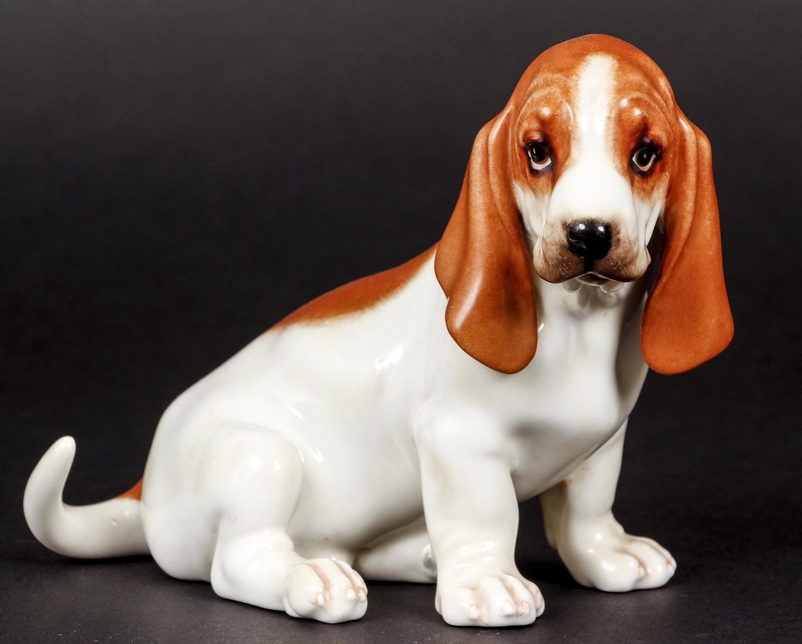 Boehm Porcelain Sitting Basset Hound: E. M. Boehm Studios, Sitting Basset Hound, glazed porcelain, c. 1950s or 1960s, Boehm script signature on base, 5.5 x 7.5 x 3.5 inches.
