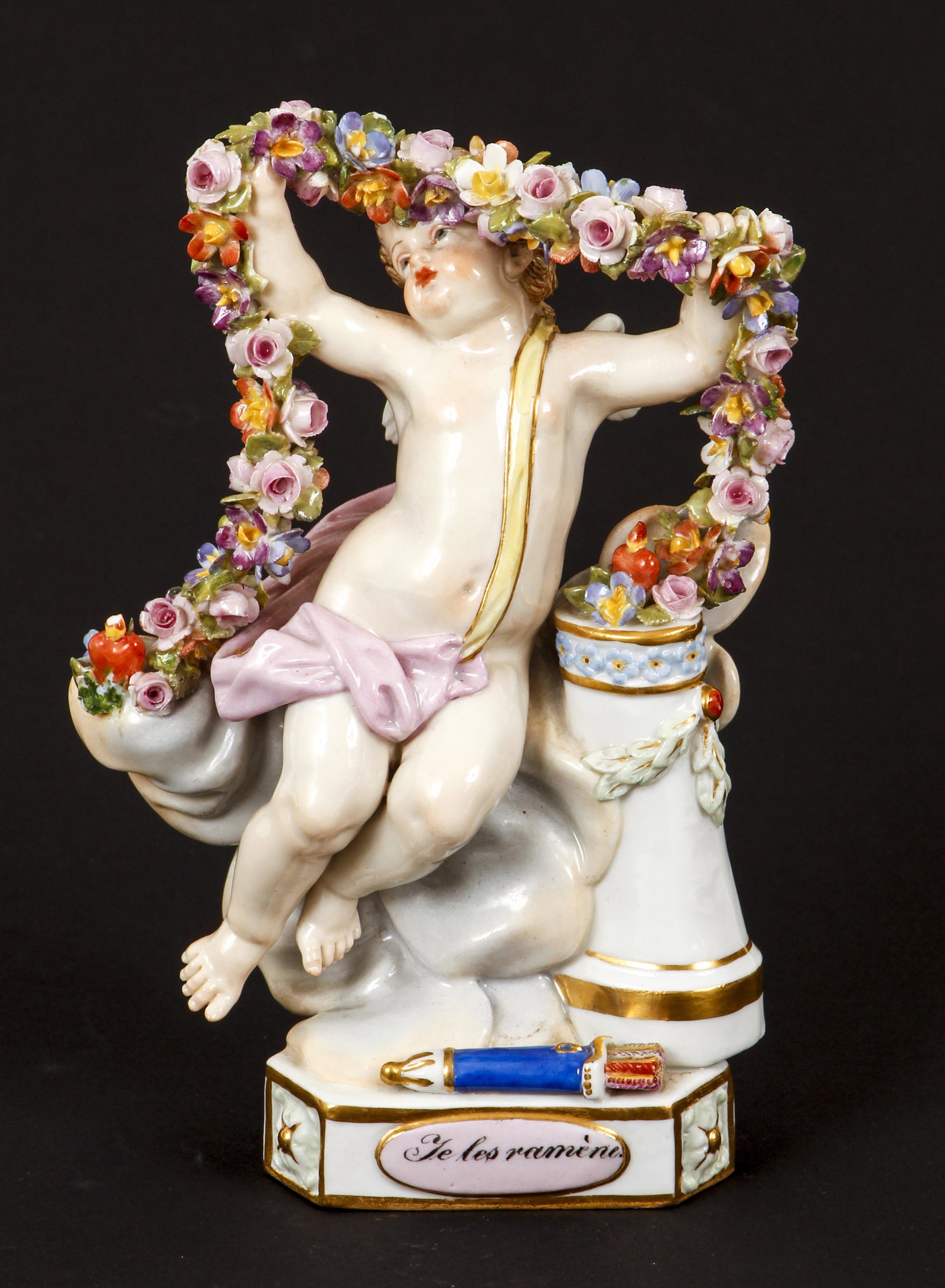 Meissen Je les Ramene Ceramic Figure of Cupid: Meissen, Je les Ramene Ceramic Figure of Cupid holding up a floral garland, 20th century, hallmark on bottom, also stamped 144 and initials FR, 5.75 inches tall, Cupid with a yellow sash and pink drap