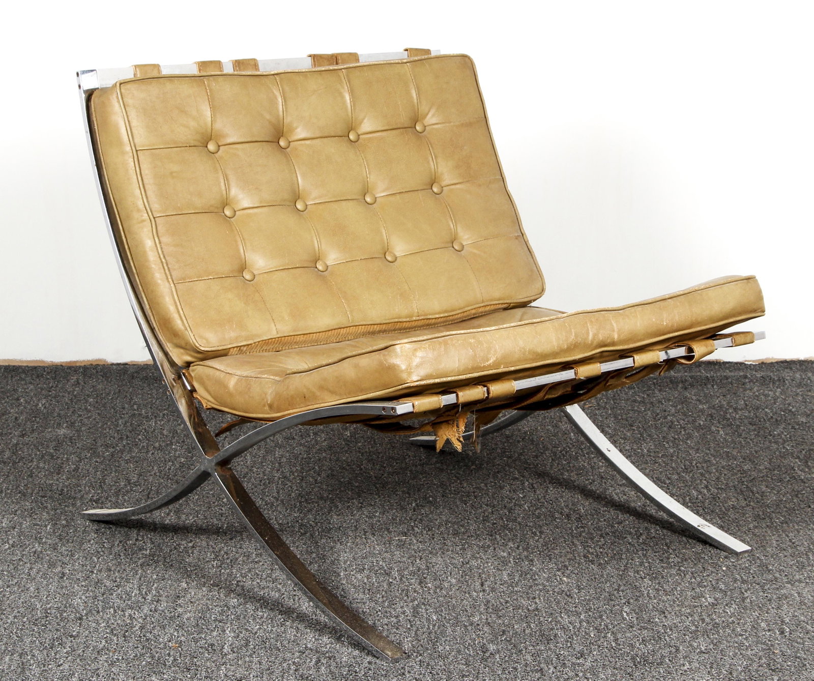 Chrome & Pleather Barcelona-Style Chair: Barcelona-style chair with metal frame and brown pleather upholstery, featuring strap supports and tufted pleather cushions. Approximately 29 H x 21 W x 23 D inches.