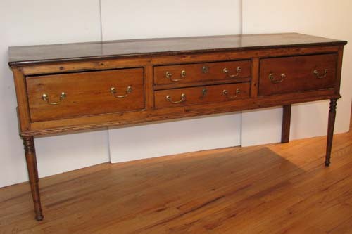 Antique English Pine Sideboard: Antique English Pine Sideboard with brass hardware, pair of center drawers flanked by larger side drawers, turned legs Date: c. 1800 Medium: pine Dimensions: 33.5 x 22 x 76 inches