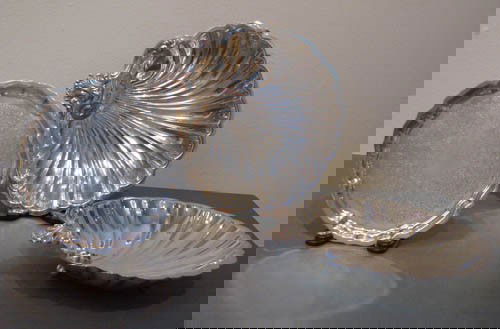 2 Silverplate shell dishes and small Reed and Bart: 2 Silverplate shell dishes with 3 ball feet and small round Reed and Barton Tray Medium: silverplate Dimensions: 2 x 10.75 x 11 inches; .5 x 8 x 8 inches Provenance: The Estate of Arnold D. and Norma