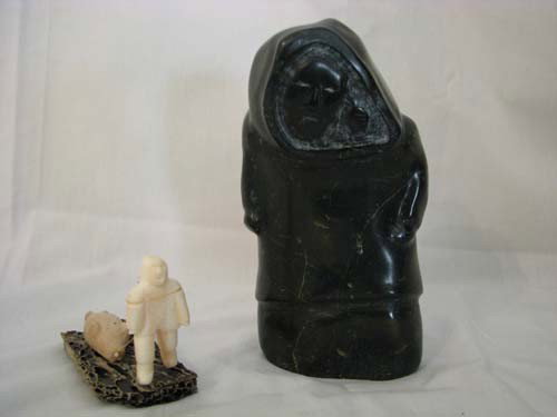 2 Carved Eskimo sculptures: Title: Carved Eskimo stone and tusk ivory faced Eskimo with seal and Carved Soapstone sculpture of Eskimo Medium: stone/ivory Dimension: large Eskimo: 6.75 inches tall Provenance:The Estate of Emily F