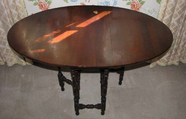 Oval walnut drop-leaf table: Title: Oval walnut drop-leaf table terminating on ring turned spider gated legs Medium: walnut Dimension: 24 x 39 x 22 inches (fully extended) Provenance:The Estate of Emily F. Oliver, Sewickley, PA