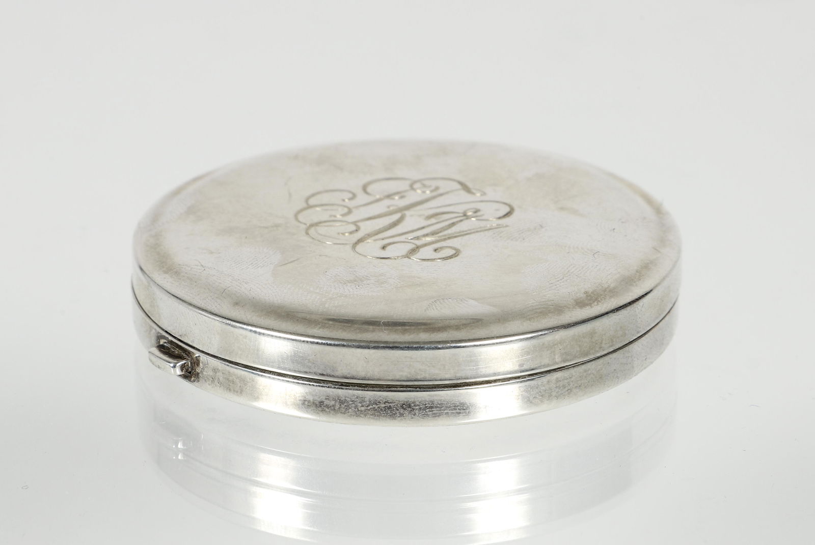 Tiffany & Co. Sterling Mirrored Compact: Tiffany & Co. sterling mirrored compact. Monogrammed "JKM". Contains Estee Lauder powder with puff. Slightly used. Measures 2 1/2" diam. C. 1990. With its original blue "Tiffany & Co." blue fabric pou