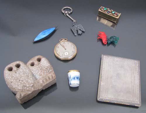 Assorted collectables including carving of owl: Title: Assortment of collectables consisting of a Russian stone carving of an owl, silver plate cigarette case, Waltham pocket watch, Danish porcelain thimble, and other collectables. Medium: stone, s