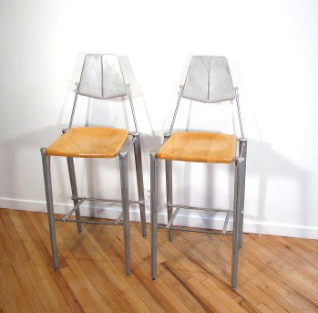 Pair of Bob Josten Cast Back Barstools: Artist: Josten, Bob Title: Pair of sand cast aluminum and wood Barstools Date: circa 1989 Medium: sand-cast aluminum steel and carved maple Dimensions: 46.5 x 19 x 17 inches each Provenan