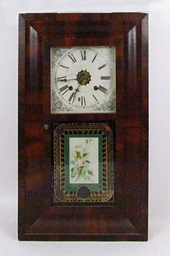 Wood Case Waterbury Lock Company Ogee Mantle Clock: Title: Reverse painted floral geometric decoration and interesting cut out view of clockworks at the center of the dial Medium: clock Dimensions: 26 x 15.5 x 4.25 inches Signature: sticker on back and