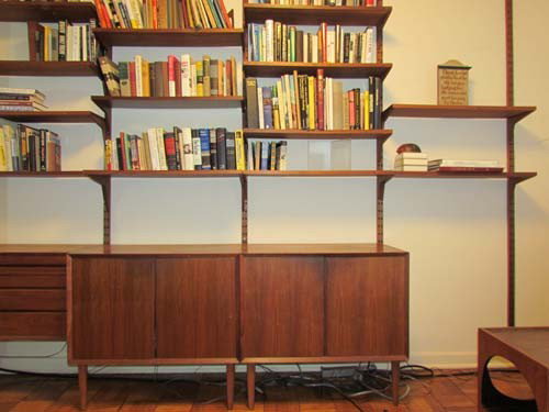 Poul Cadovius System Cado wall system: Artist: Cadovius, Poul Title: System Cado wall system with 13 shelves on 5 rails, wall mounted dresser with 3 drawers, and 2 attached footed cabinets Medium: Afrormosia Teak Dimensions: 88 x 127 x 19.