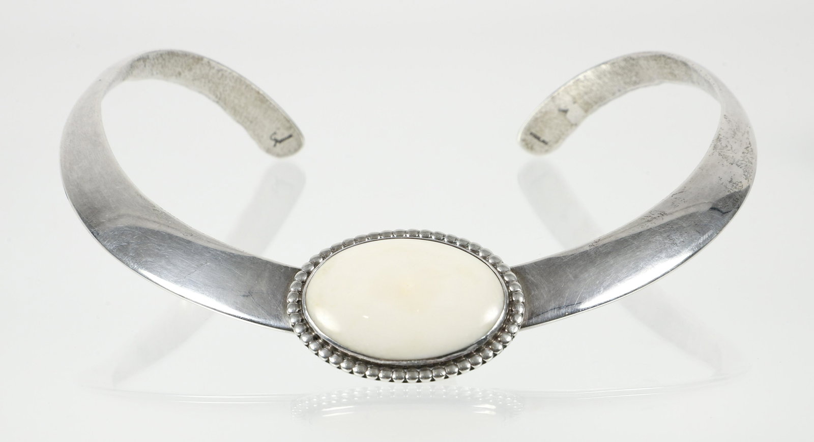 Sterling Duane Maktima Hopi Collar: Sterling bone collar by SW Native American artist Duane Maktima. The molded sterling collar necklace is decorated with a polished oval piece of ancient animal bone that is set in a decorative mounting