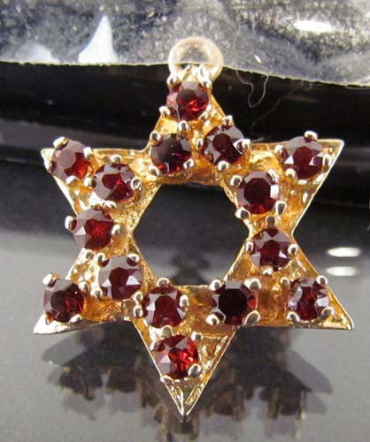 Ruby and 14 k Gold Star of David Charm: Title: 14 caret gold Star of David with 15 rubies set on 4 prongs each Medium: gold and rubies Dimensions: .075 ozt