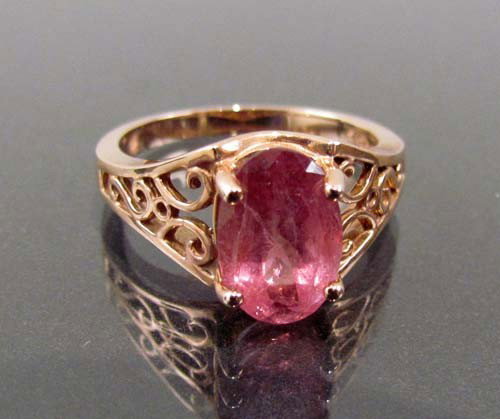 14kt rose gold ring with a pink tourmaline: Title: 14kt hallmarked rose gold ring of solitaire style containing an oval cut pink tourmaline Dimensions: tourmaline - 2.20ct, gold 2.55 pennyweights