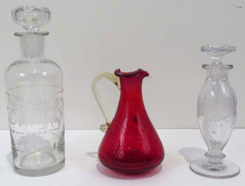 Dorflinger pitcher & 2 perfume bottles: Title: Dorflinger small red Pitcher with crackle finish, decorated cologne bottle w stopper & perfume Bottle with decorated top and sides Medium: blown glass with incised decoration Dimensions: 7.5 in