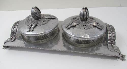 Hand wrought Rodney Kent Silver Co serving tray: Title: Hand wrought Rodney Kent Silver Co serving tray with pair of glass condiment dishes with tulip finial lids Medium: hammered aluminum Dimensions: 4.25 x 13.25 x 5.75 inches Signature: stamped Ro