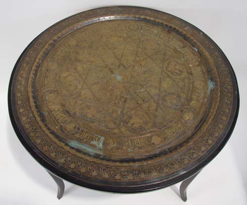Syrian Brass Tray converted to Table: Artist: Syrian Craftsman Title: Brass and Wood Table made from Syrian Wall Decorative Tray with extensive inscriptions Date: prior to 1950 Medium: hammered Brass and wood Dimensions: 20 x 28.5 x 28.5 